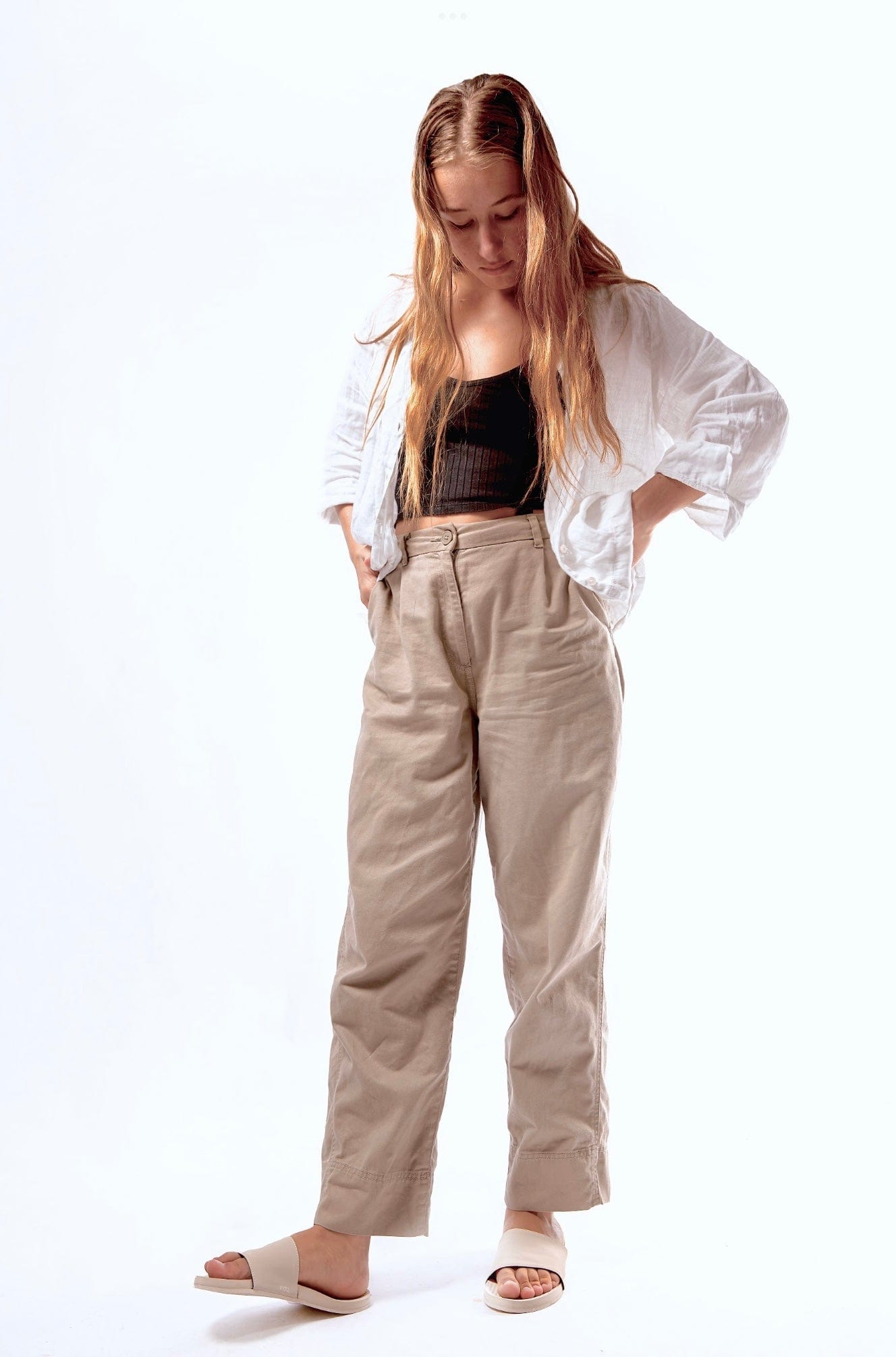 Woman in casual outfit looking down wearing Indosole sea salt slides