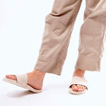 Woman walking in Indosole sea salt slides paired with relaxed khaki trousers