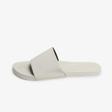 Side profile of sea salt sneaker sole slide in soft off-white cream